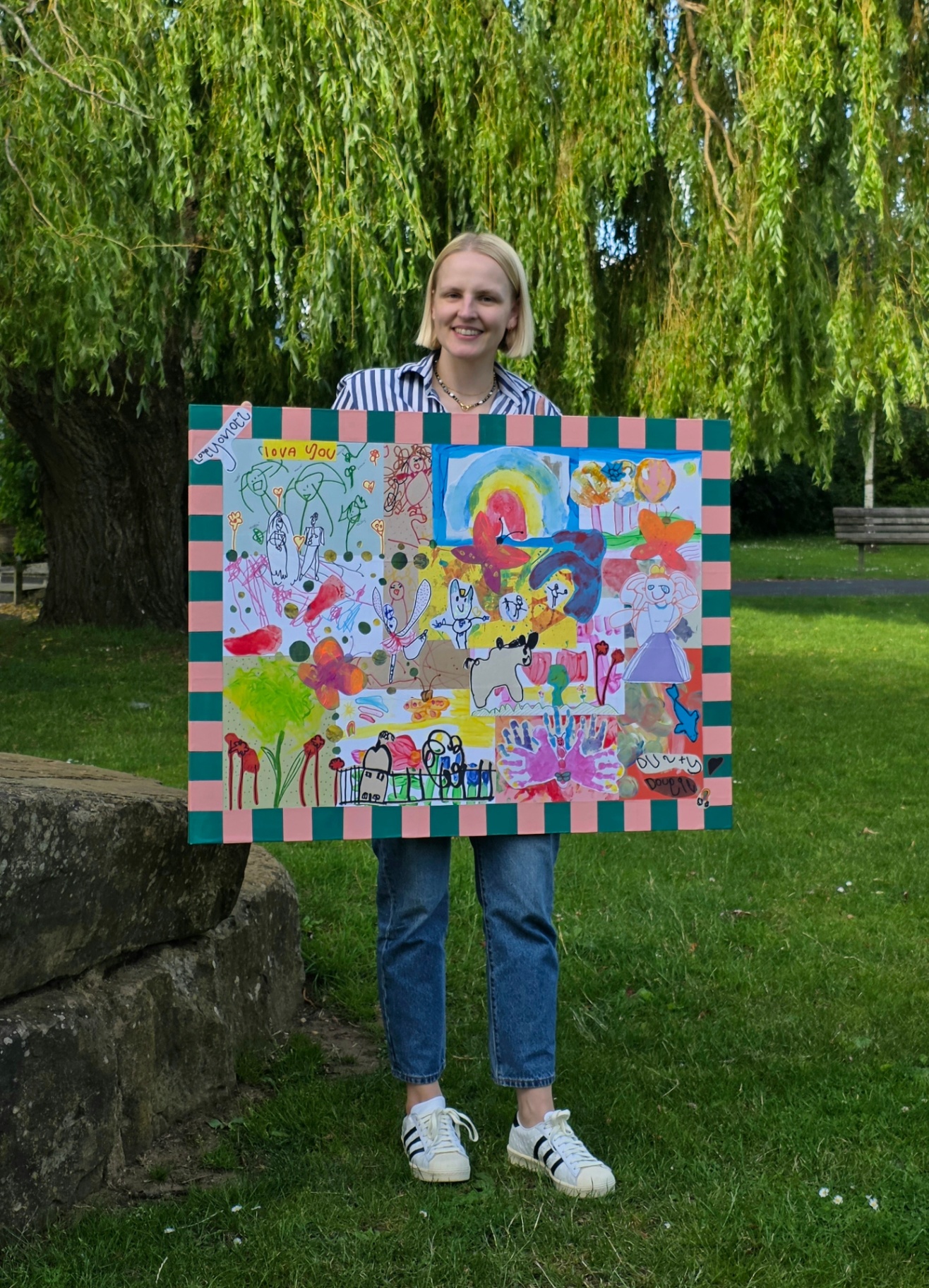 Artist holding finished collage in park
